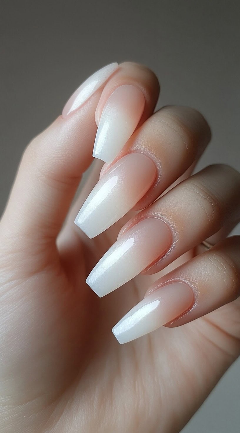 Long coffin-shaped nails featuring a seamless ombre transition from natural pink to crisp white for a timeless bridal look.
