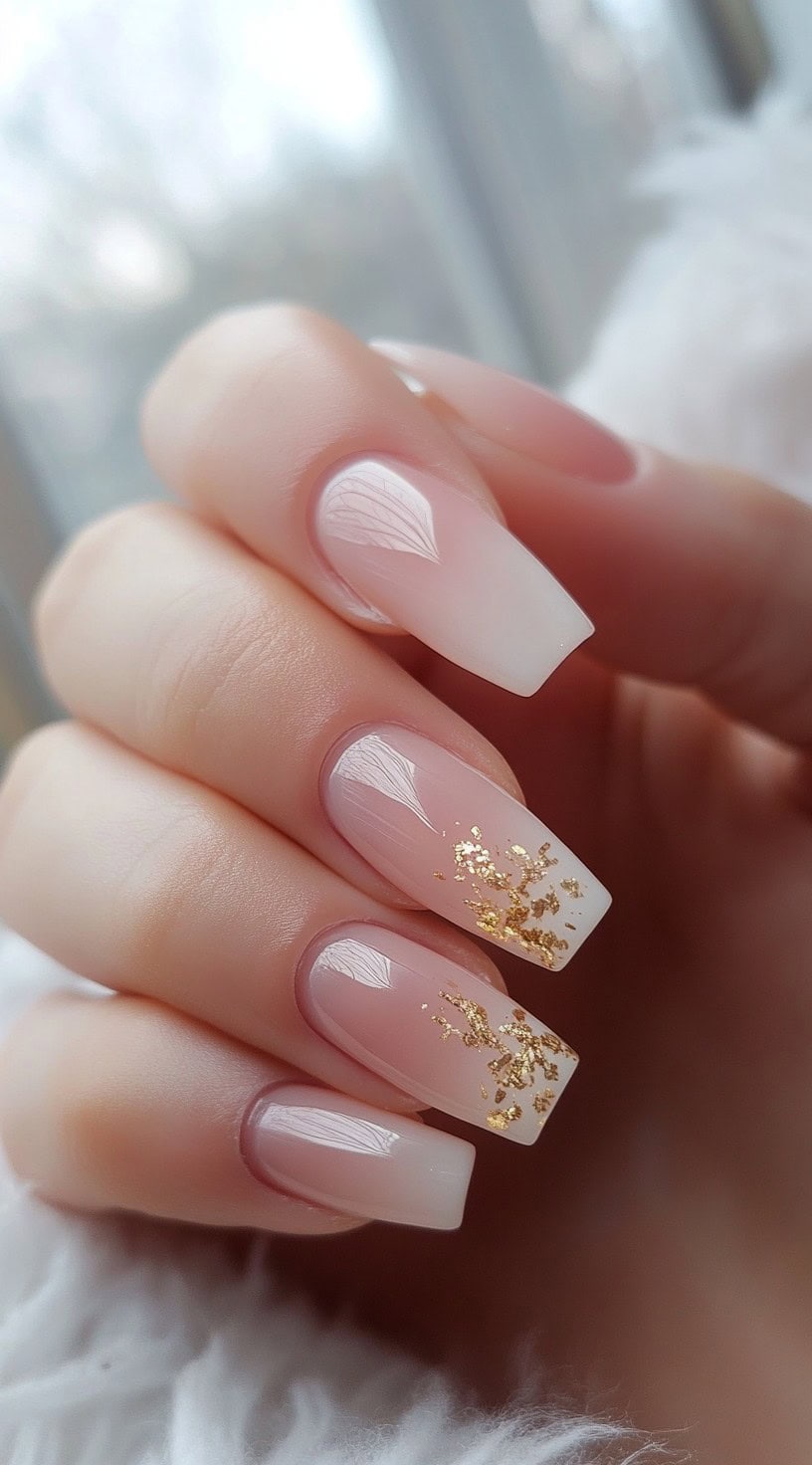 Elegant coffin-shaped nails with a nude to white ombre and gold foil accents.