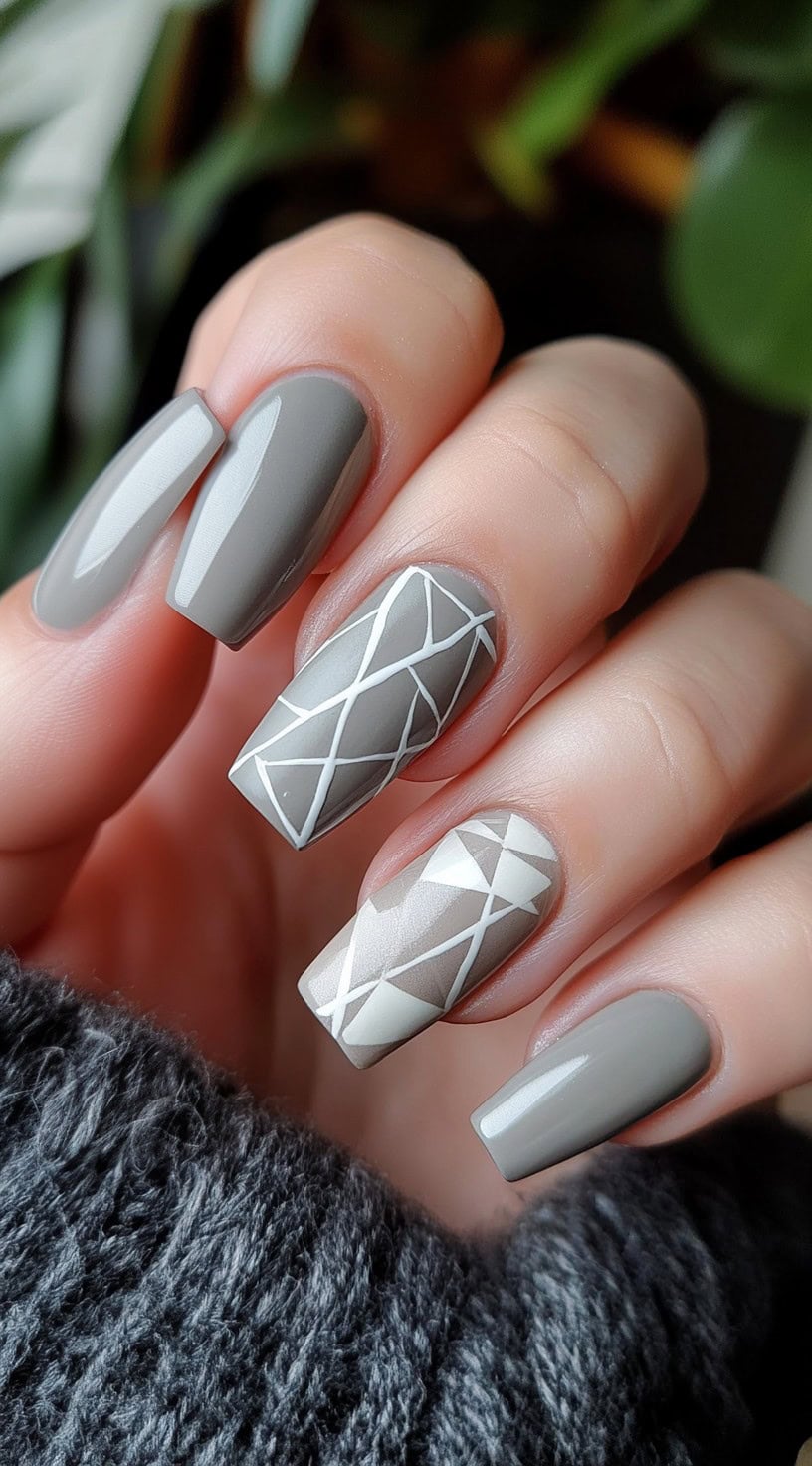 Coffin-shaped gray nails with white geometric line patterns on accent nails.