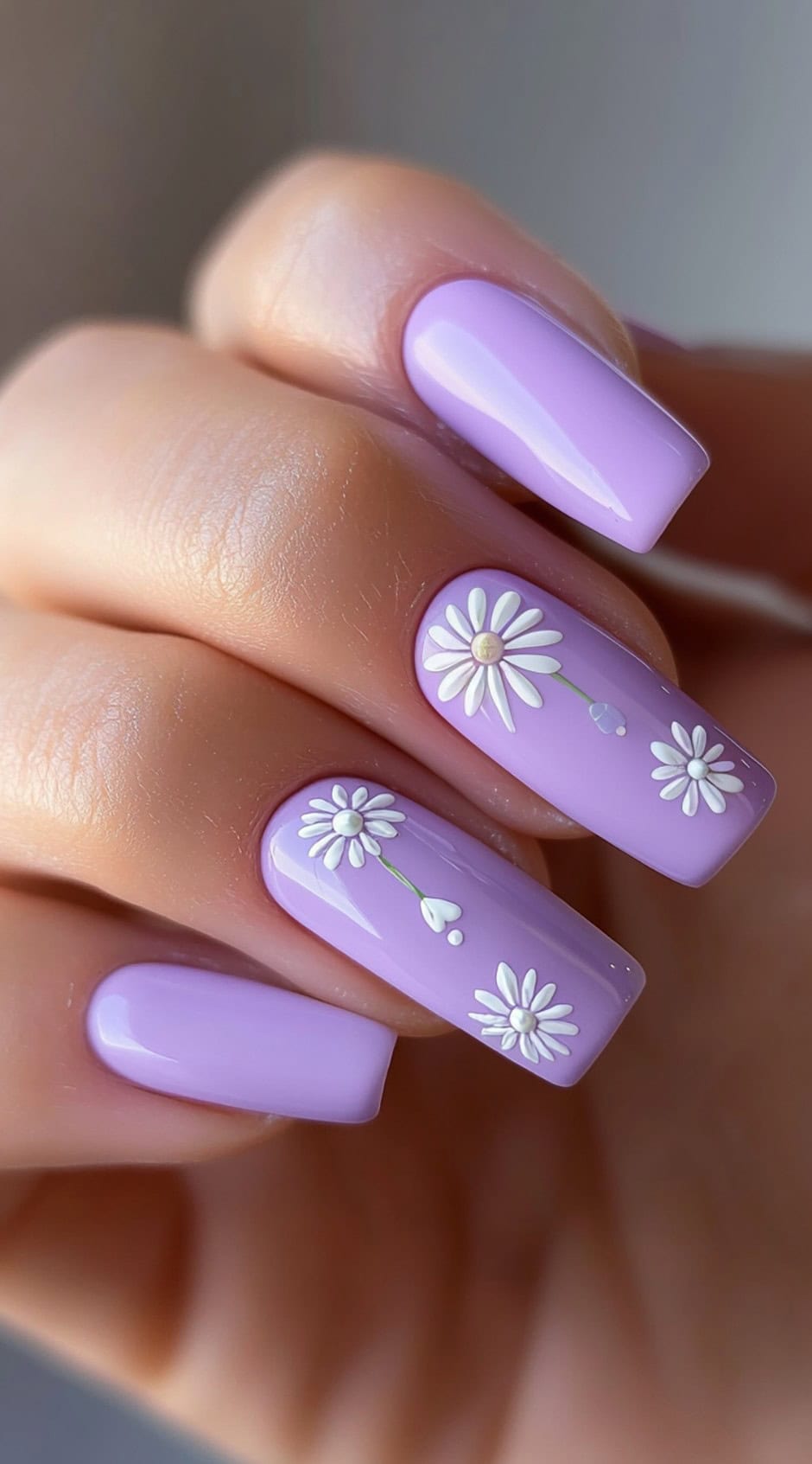 Square-shaped nails with a pastel purple base and white daisy accents.