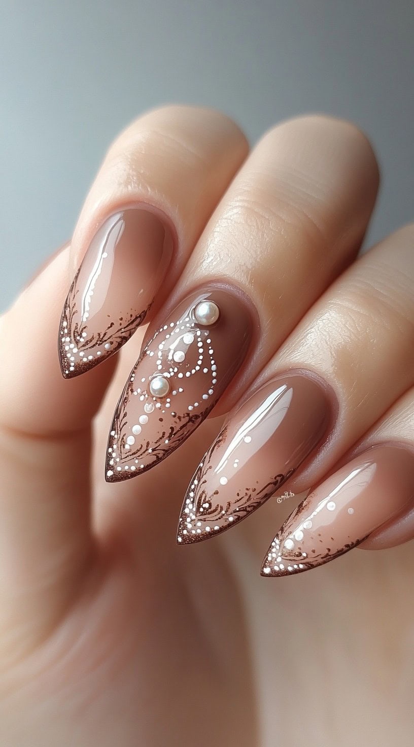 Almond-shaped nails with a brown ombre base are detailed with white microdots and embellished pearls.