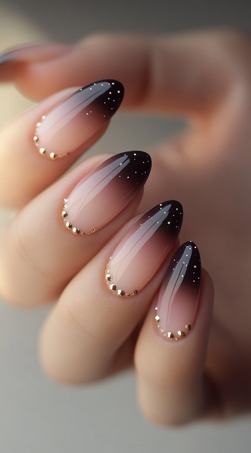 Almond nails fade from brown to soft pink and are embellished with small gold studs along the cuticle line.