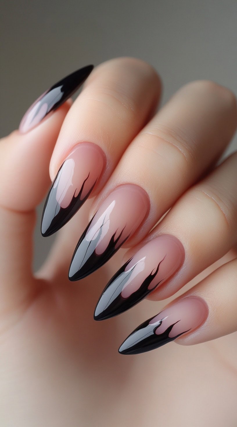 Almond-shaped nails with pink bases and glossy black flame designs at the tips.