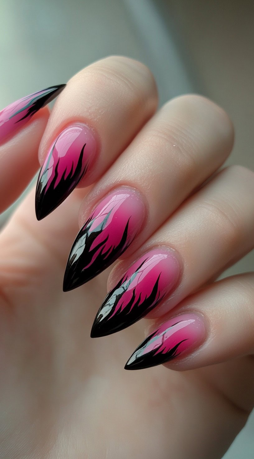Almond-shaped nails with a hot pink to black ombre base, topped with bold black flame detailing.