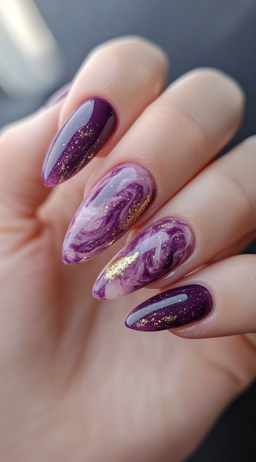Almond nails with a blend of purple marble and gold foil detailing, alternating with solid glittery purple nails.