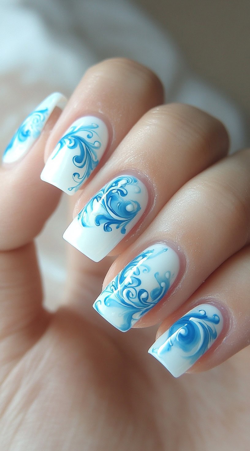 Square-shaped nails with white French tips featuring intricate blue swirl patterns.