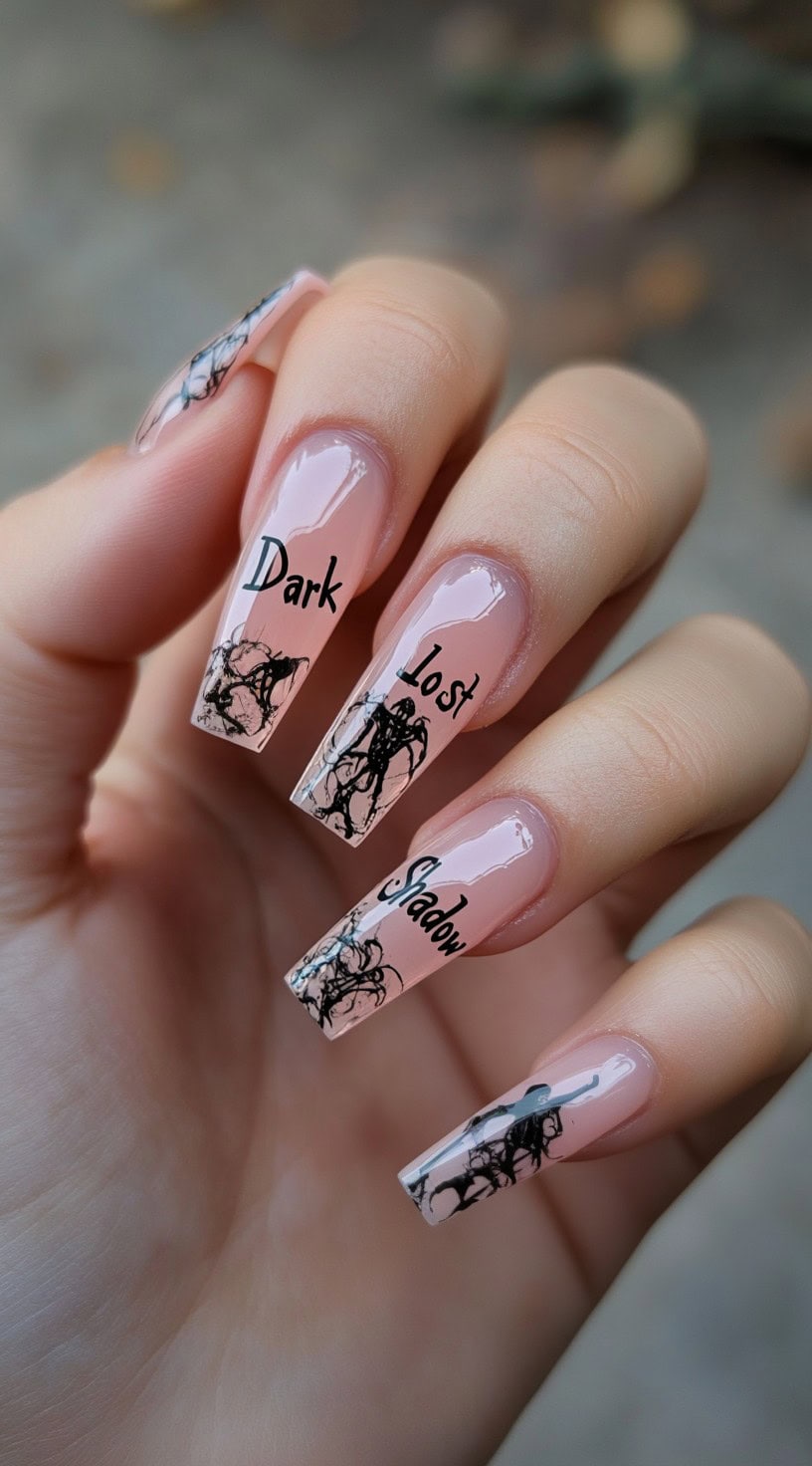 A hand with long nude coffin nails featuring black gothic text and abstract black ink-like figures.