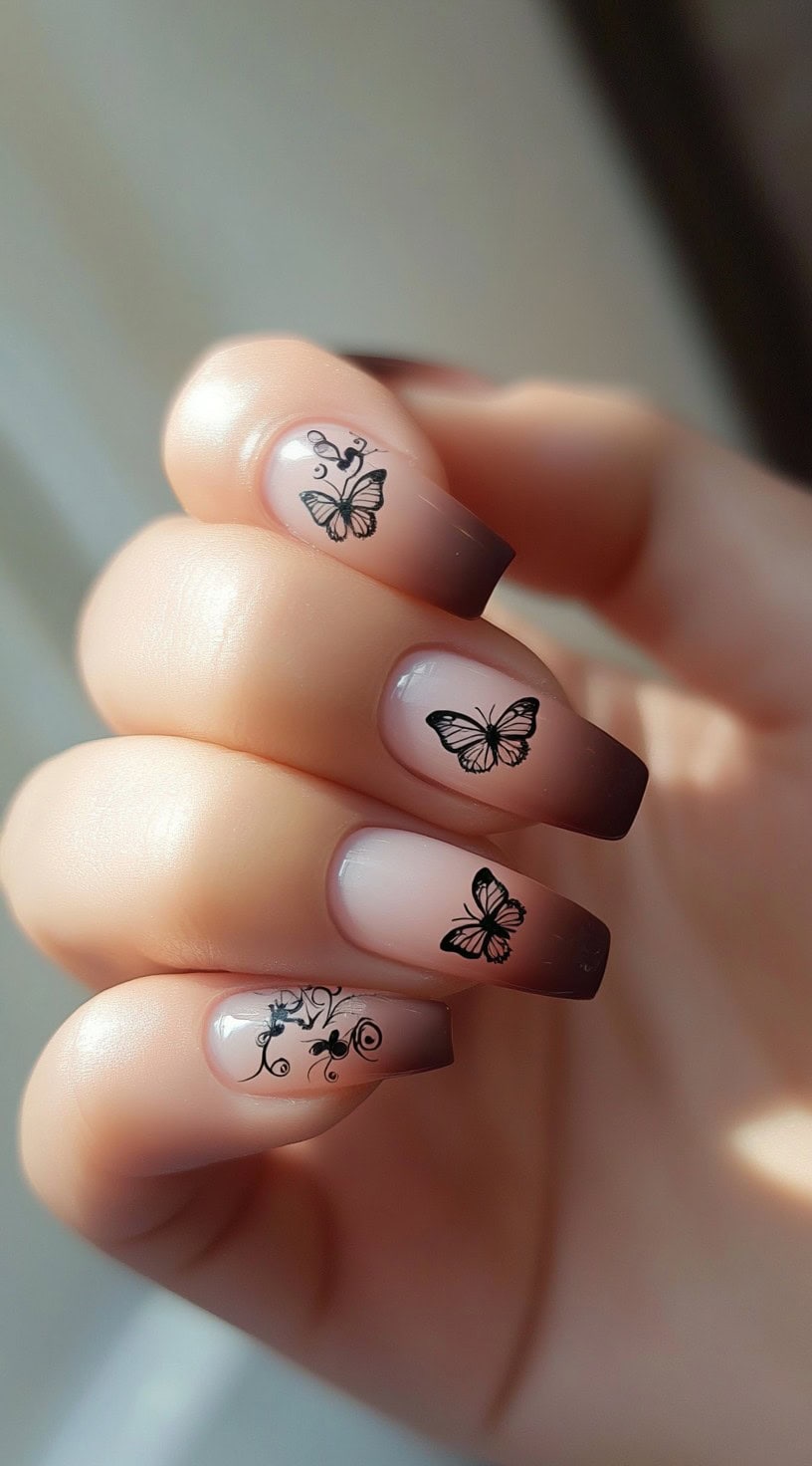Coffin-shaped nails with a pink to brown ombre base and black butterfly decals on multiple nails.