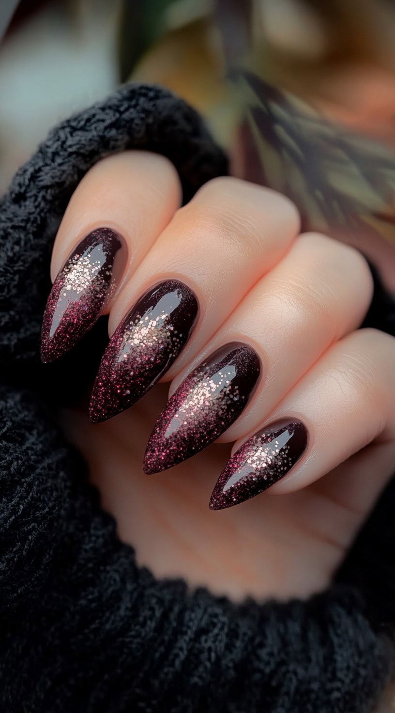 Almond-shaped nails with a deep brown base fading into pink glitter at the center and tips.