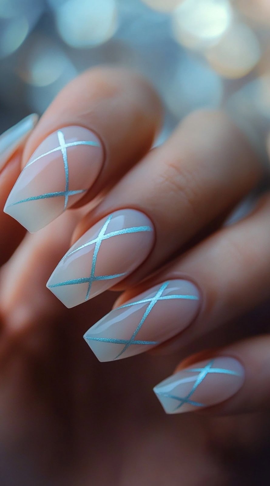 Clear nude coffin nails with crisscrossing light blue chrome stripes.