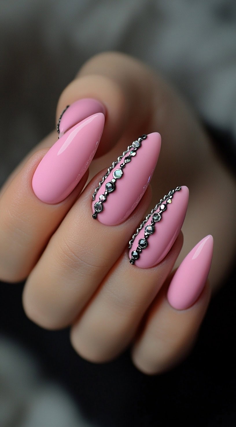 Glossy almond-shaped pink nails with vertical black metal chain embellishments.