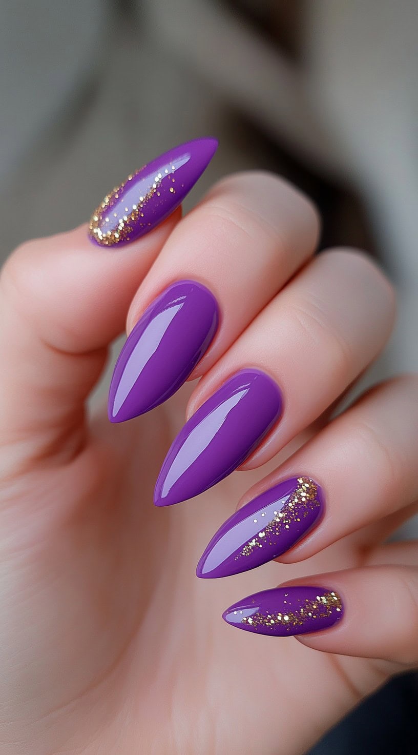 Bright purple almond-shaped nails with clear glitter fades near the cuticle on accent nails.
