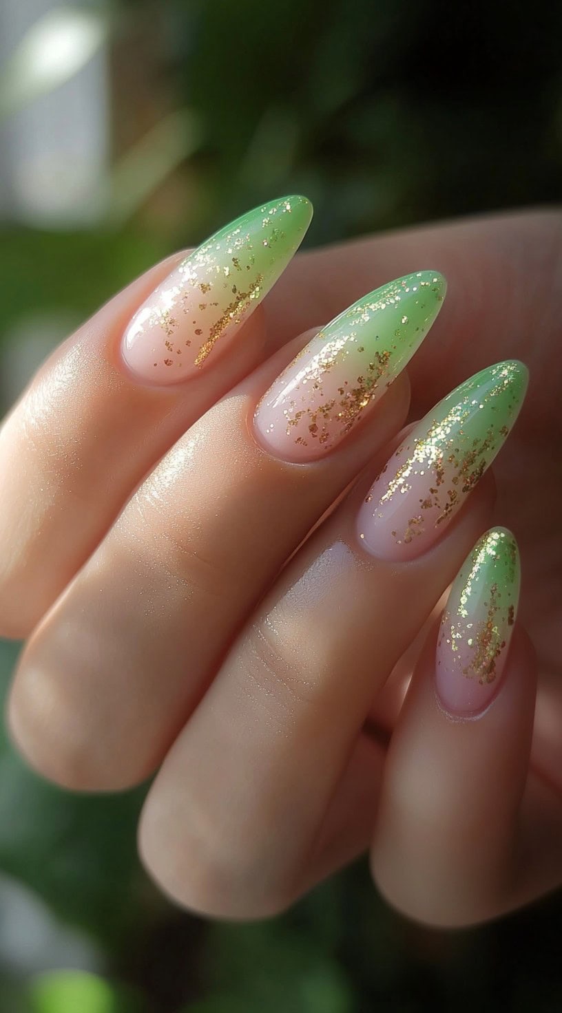 Green and pink ombré nails with gold glitter on almond-shaped nails