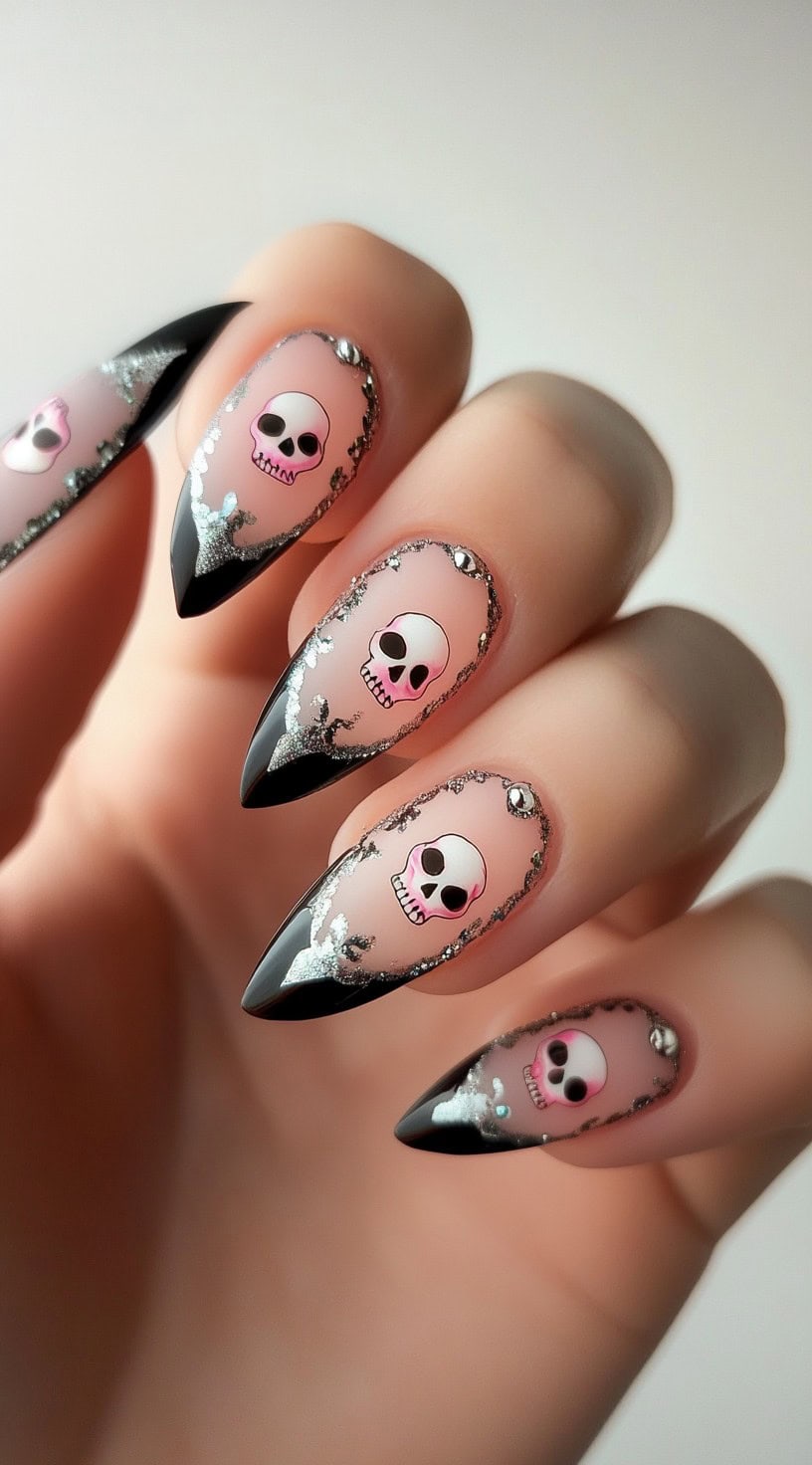 Pointed pink nails with black French tips, silver foil, and skull designs framed in glitter.