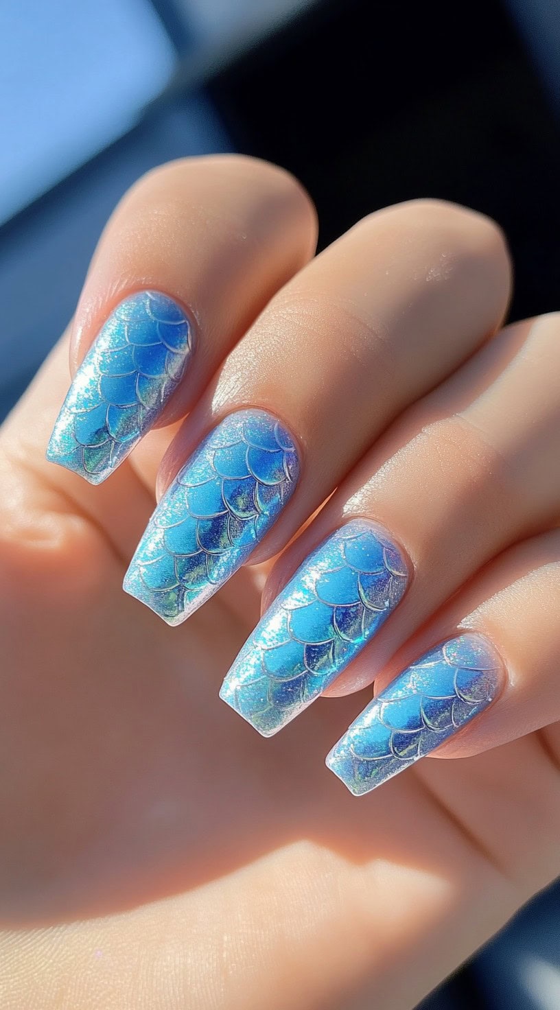 Light blue square nails with a shimmering mermaid scale pattern.