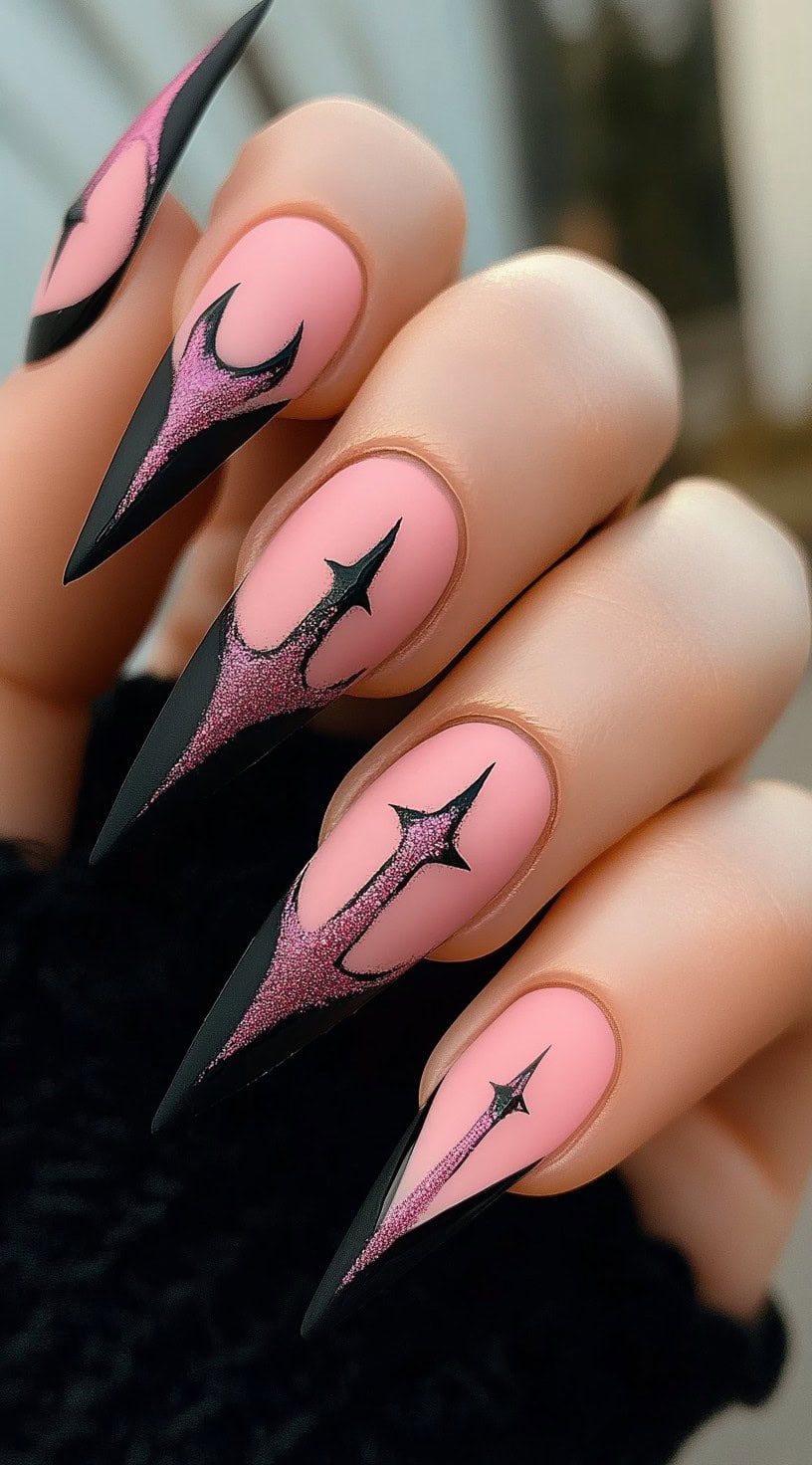 Stiletto-shaped nails with matte pink base and black-pink flame-like gothic dagger design.