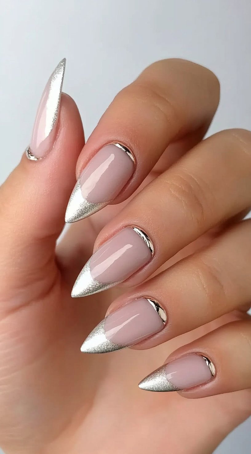 Almond-shaped nails with a nude base and a metallic silver crescent at the cuticle line.