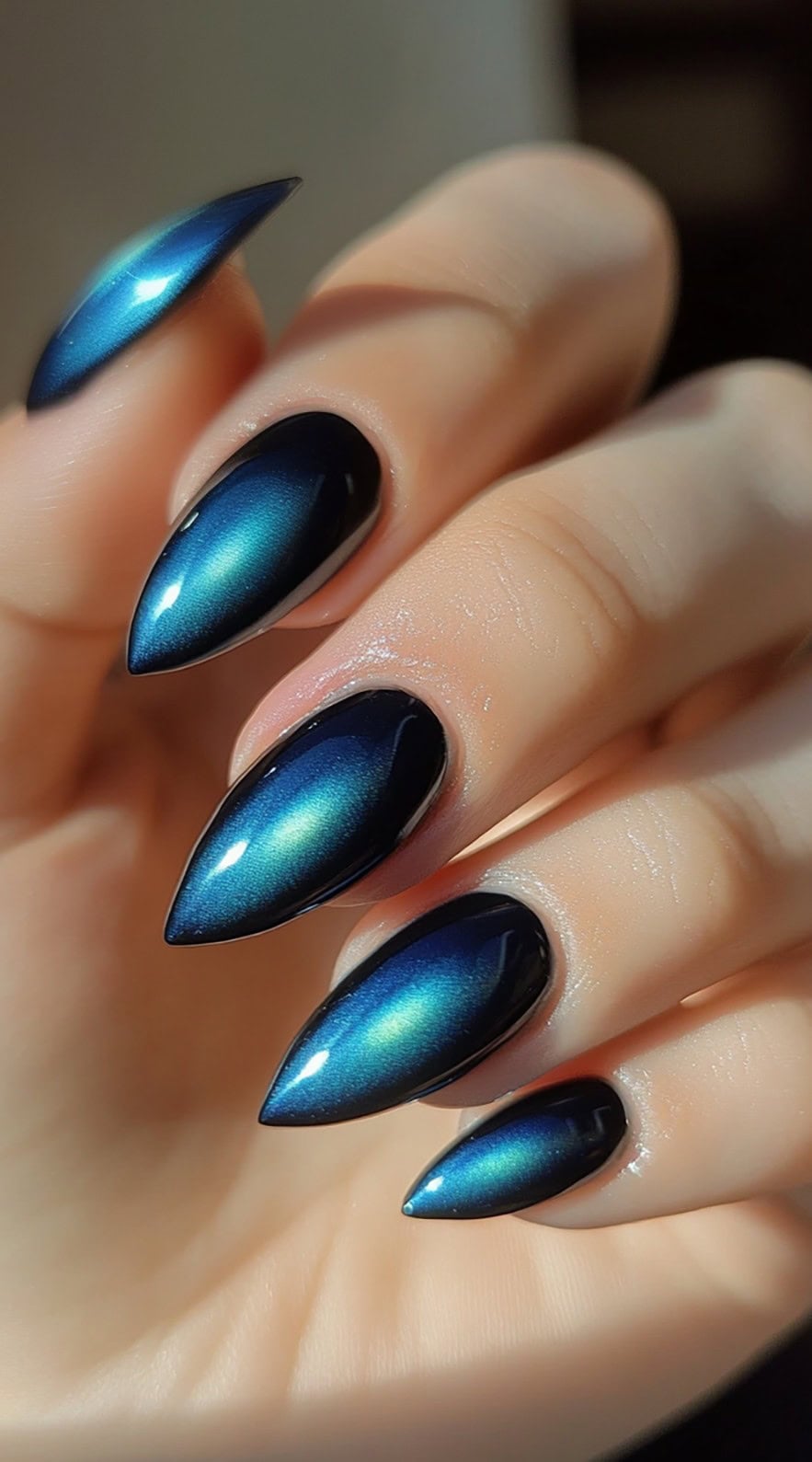 Almond-shaped nails with a deep blue aura glow, enhanced by a magnetic cat-eye shimmer that shifts under light.