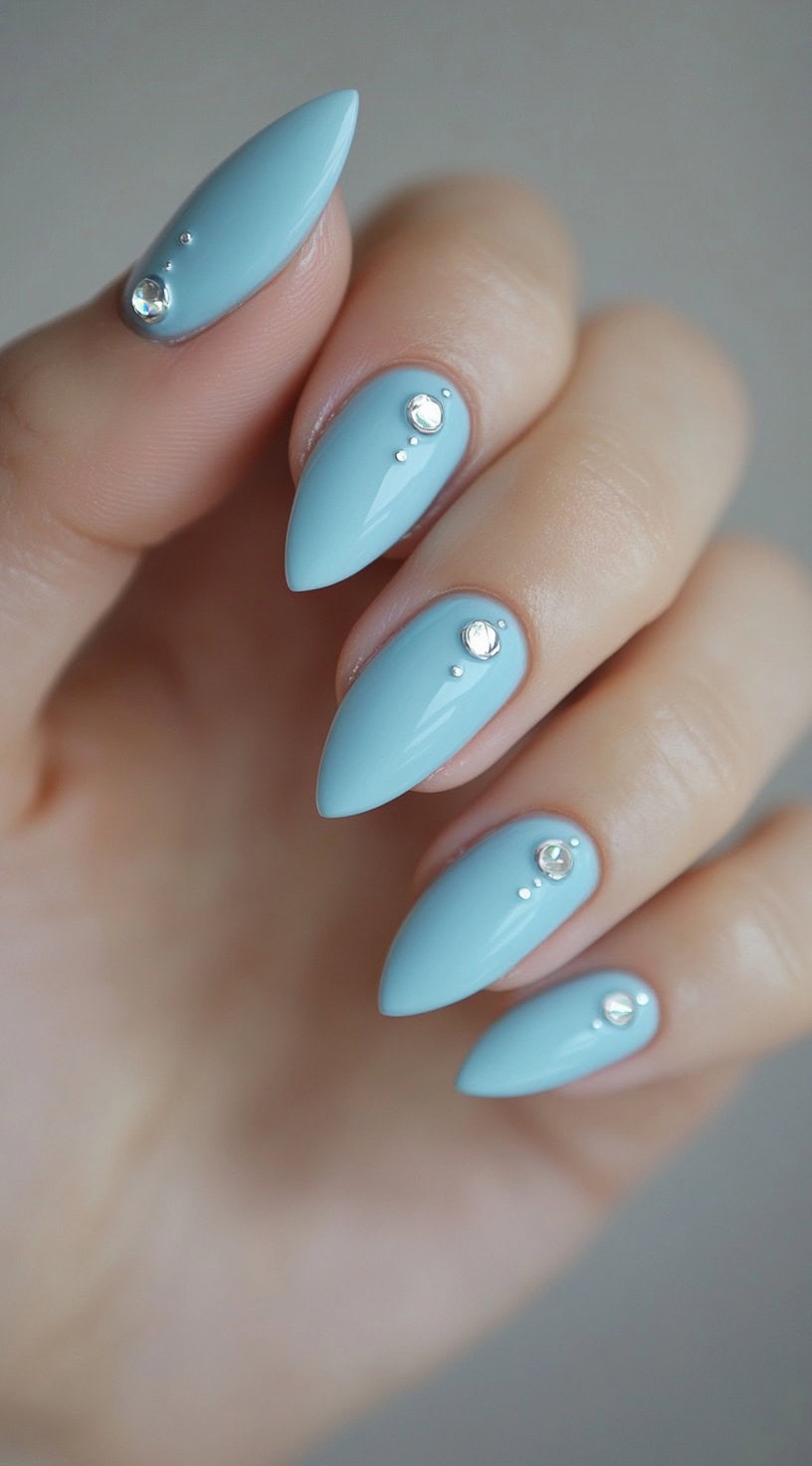 Light blue almond nails with minimalist rhinestone accents on each nail.