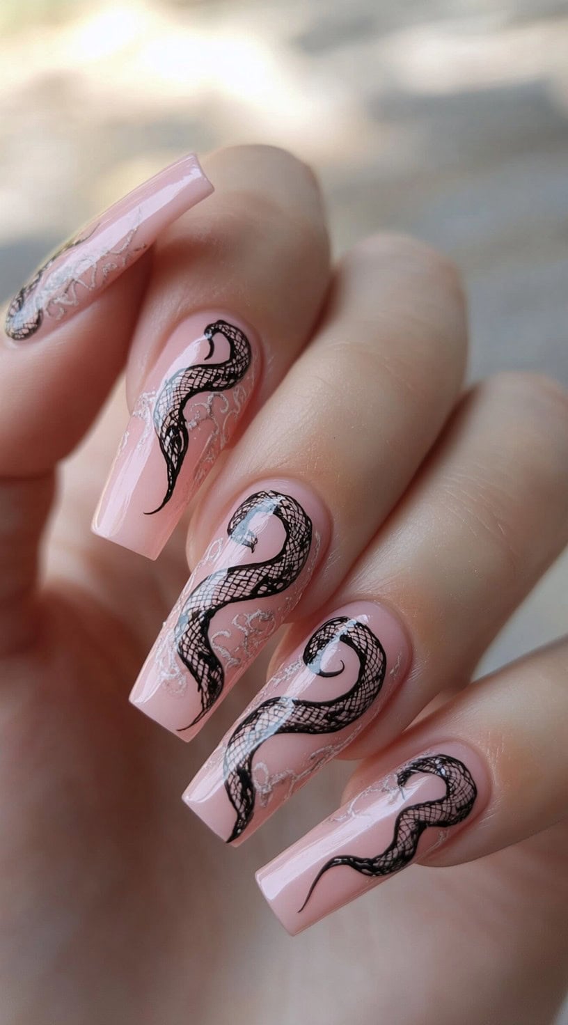 Long pink square nails with black lace-style snake designs coiling across each nail.
