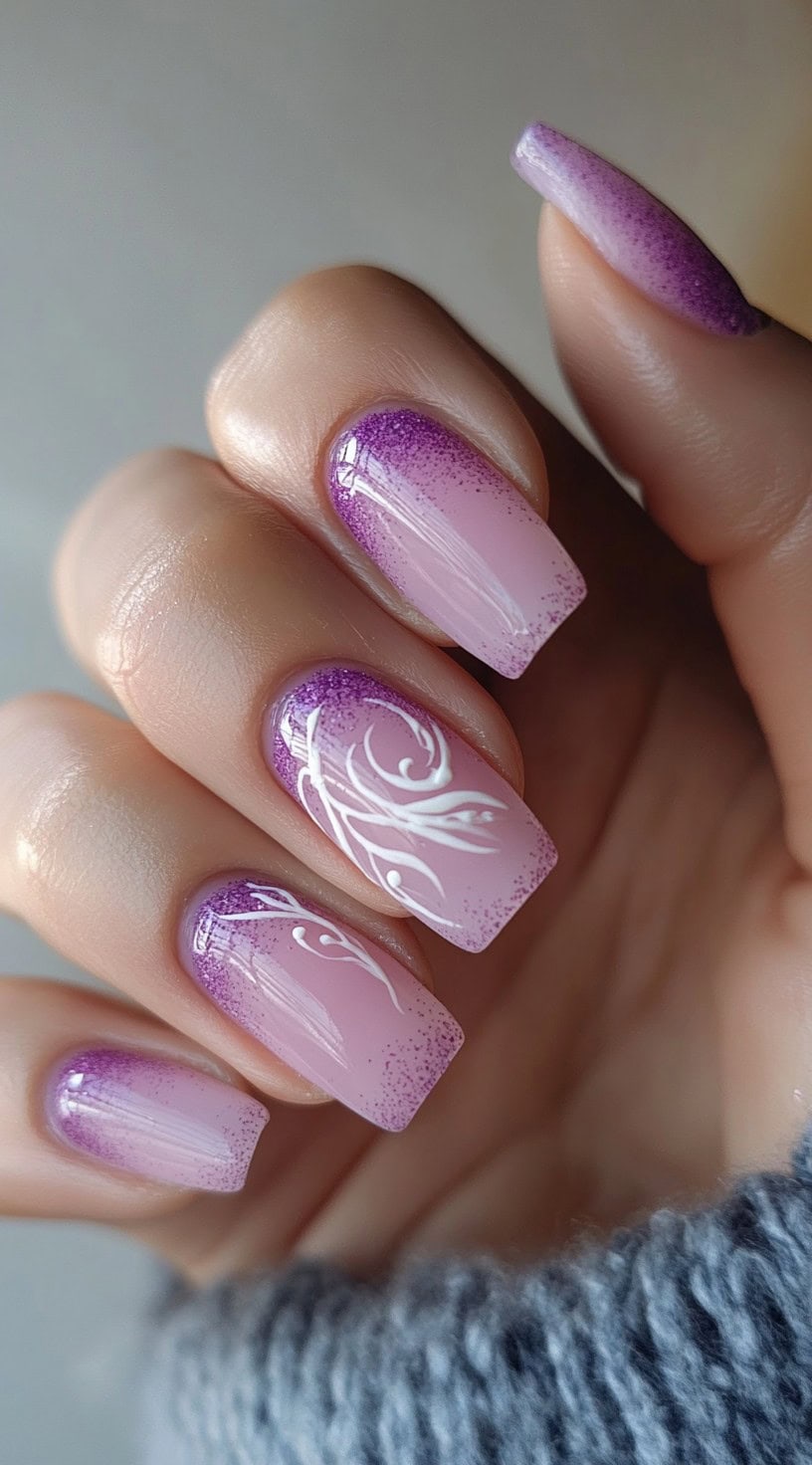 Square nails with a light pink to purple ombre gradient and intricate white swirl designs over a glossy finish.
