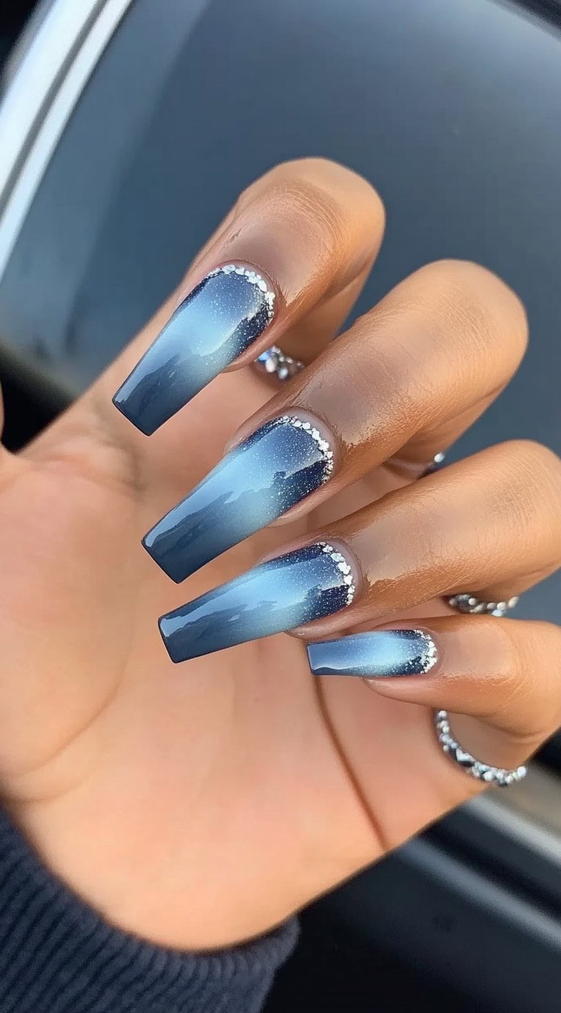 Coffin-shaped nails featuring a royal blue aura ombré with silver rhinestone embellishments along the cuticle.