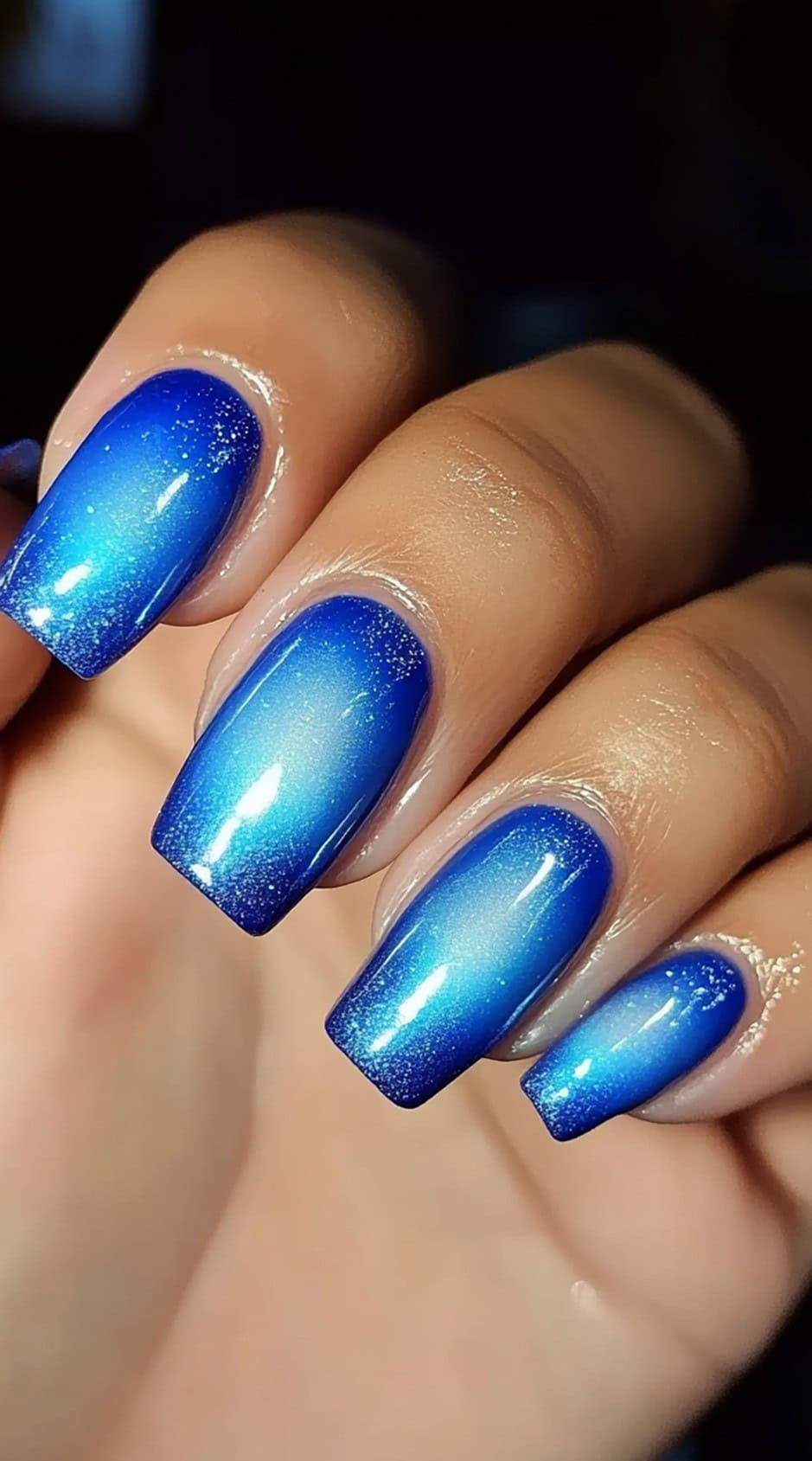 Square-shaped nails with a glowing blue aura fade, transitioning from a deep royal blue into a soft, white center.