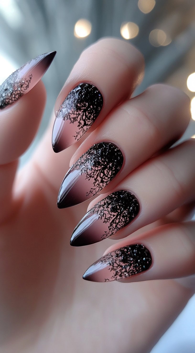 Stiletto nails featuring a sheer pink to black ombre with a black lace-like cracked pattern overlay at the tips.