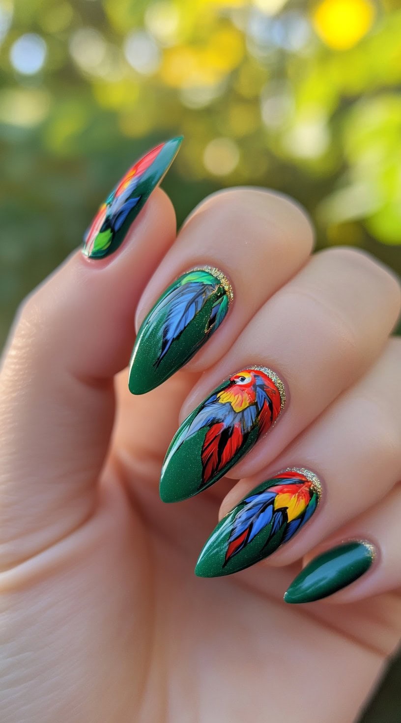 Stiletto-shaped nails with dark green base and colorful parrot feather designs.
