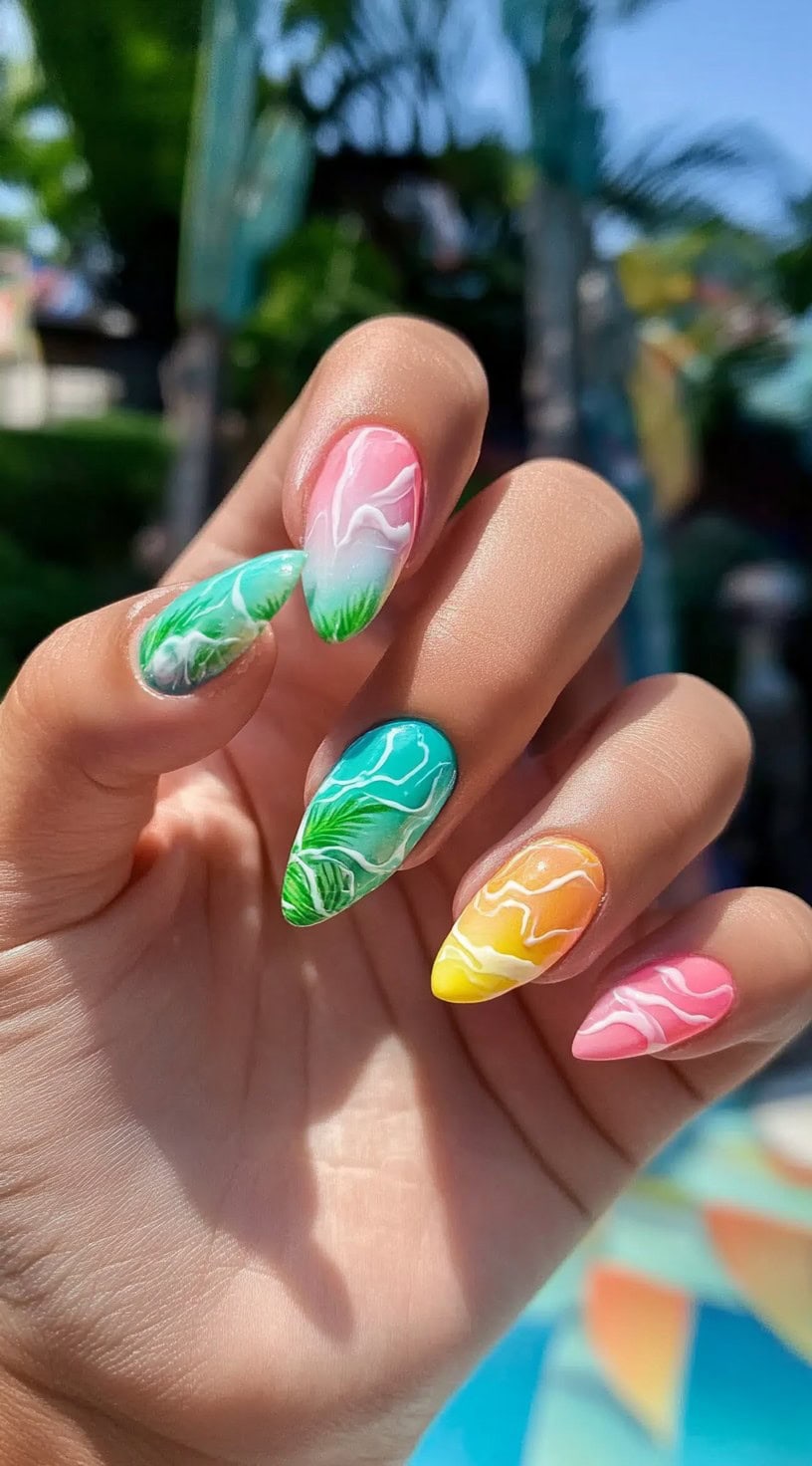 Almond-shaped nails with multi-colored swirl patterns and tropical leaf accents.